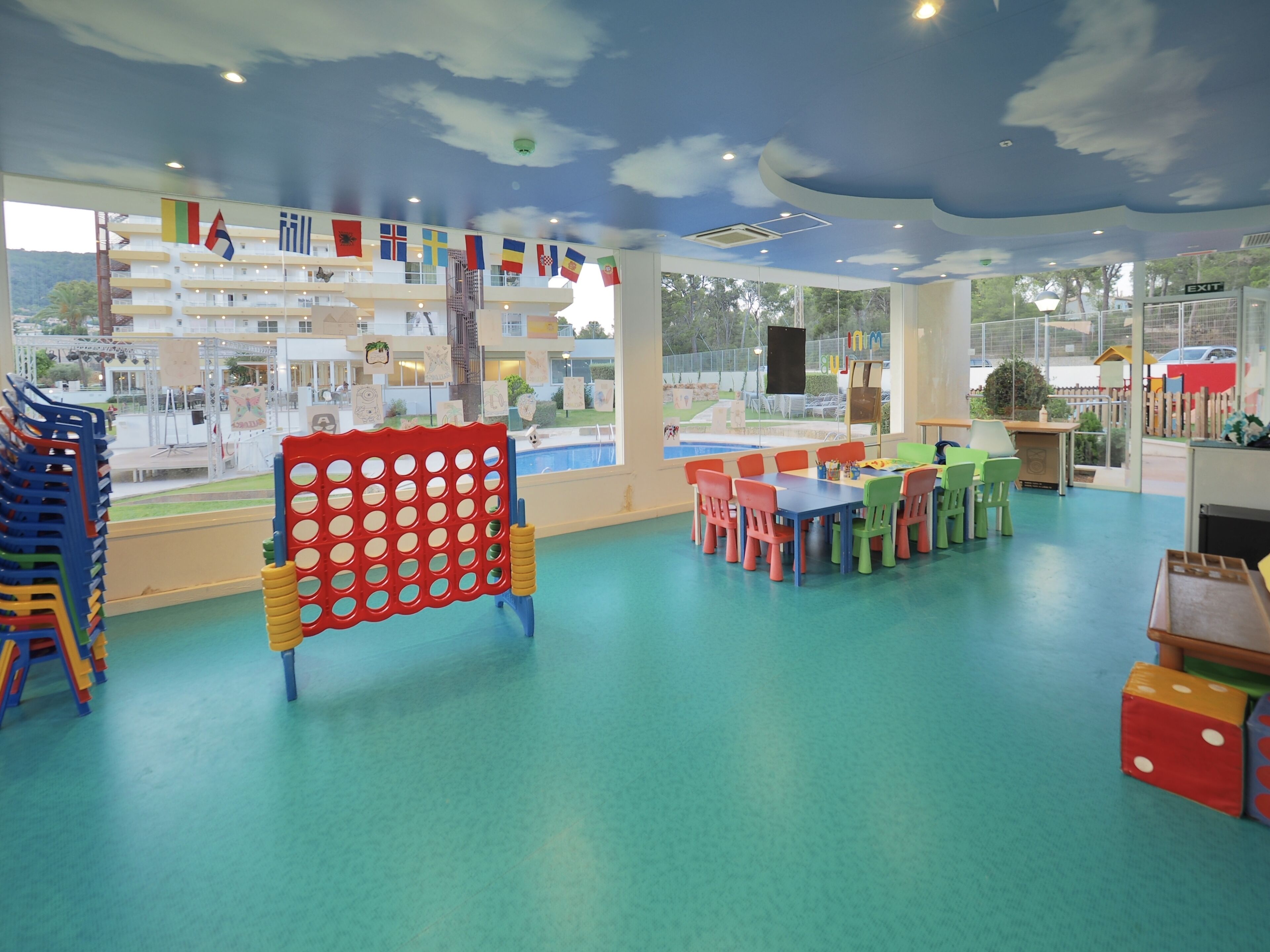 Ein Kinderspielbereich mit bunten Möbeln und Wandgemälden an der Decke.