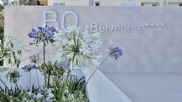 A building with a sign that reads "Belvedere" and a flower arrangement in the foreground.