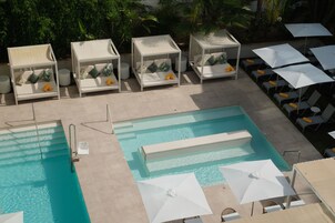 Una piscina al aire libre, sombrillas, tumbonas