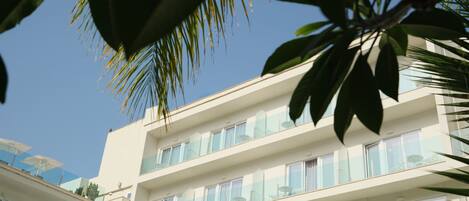 A multi-story hotel with balconies and large windows.