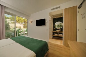 A modern bedroom with a bed, a TV, and a view of the outdoors. - BQ Paguera Boutique Hotel - Adults Only (Calvia)
