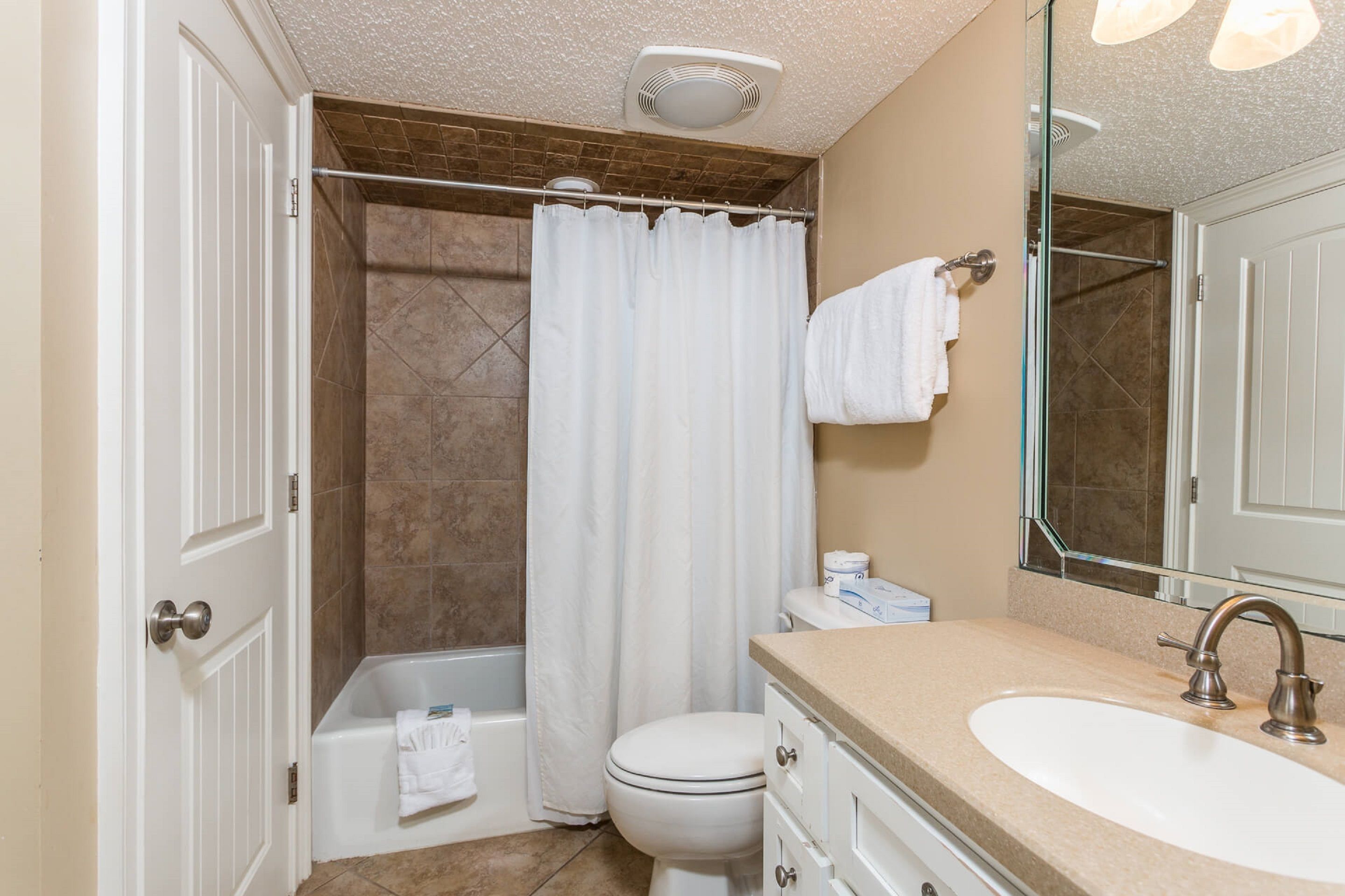 A bathroom with a bathtub, toilet, and sink.