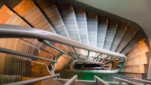 A spiral staircase with wooden steps and metal railings. - Hotel Prince Albert Wagram (Paris)