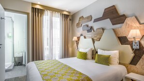 A hotel room with a large bed, a desk, and a bathroom. - Hotel Prince Albert Wagram (Paris)