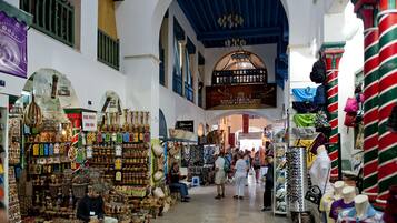 An indoor market with various stalls selling handicrafts and textiles.