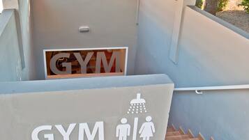 Entrada a un gimnasio con un letrero que indica instalaciones para hombres y mujeres.