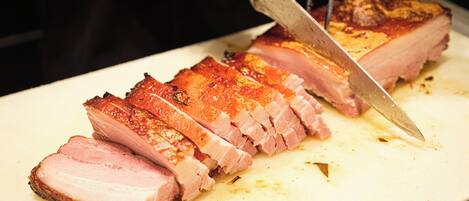 A close-up of a cooked meat dish being sliced with a knife.