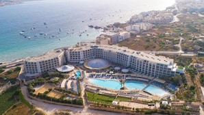 A large hotel with multiple swimming pools and a marina with boats. - db Seabank Resort and Spa (Mellieha)