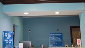 A reception desk with a blue sign indicating one car per room and no golf carts. - Americas Best Value Inn Port Aransas (Port Aransas)