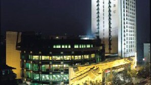 Un hôtel moderne doté d’une tour imposante, de nombreux étages et d’une façade bien éclairée.
