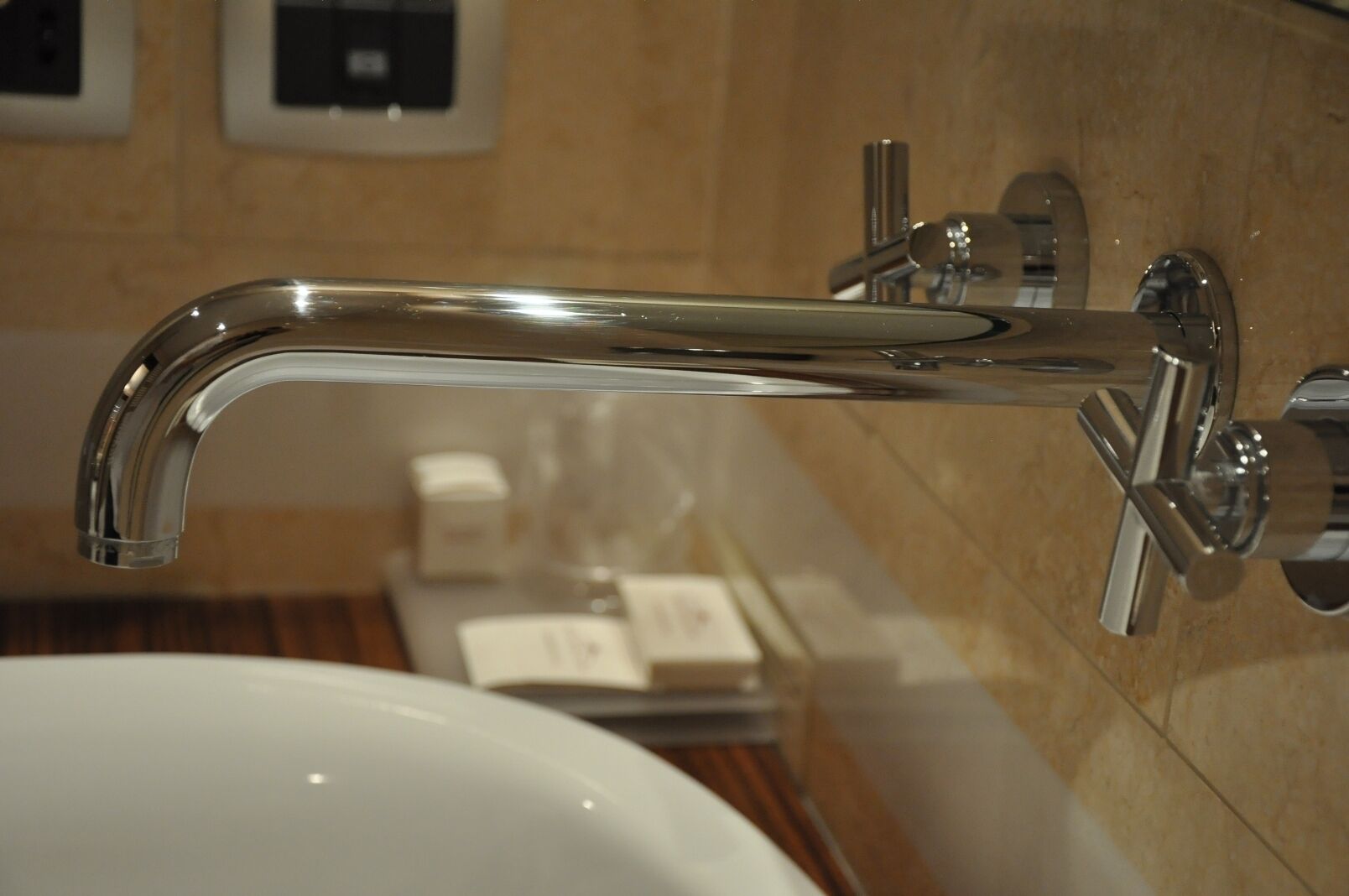 Un baño moderno con grifo cromado, lavabo blanco y espejo.