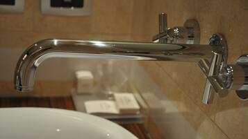 Un baño moderno con grifo cromado, lavabo blanco y espejo.