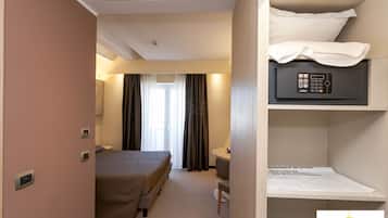 Ein Hotelzimmer mit Bett, Schreibtisch, Stuhl, kleinem Tisch und Minibar.