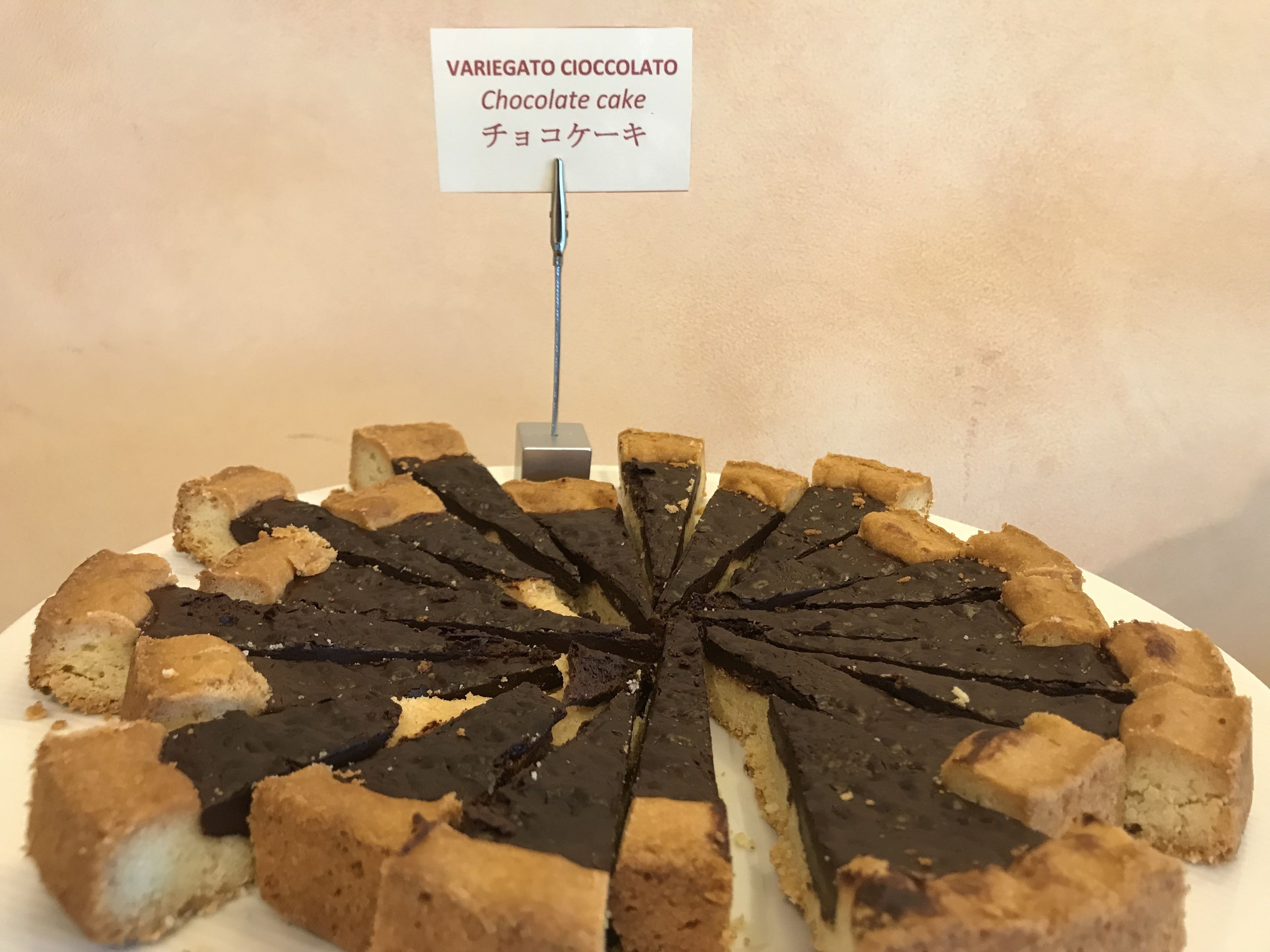 Un pastel de chocolate con un cartel encima.