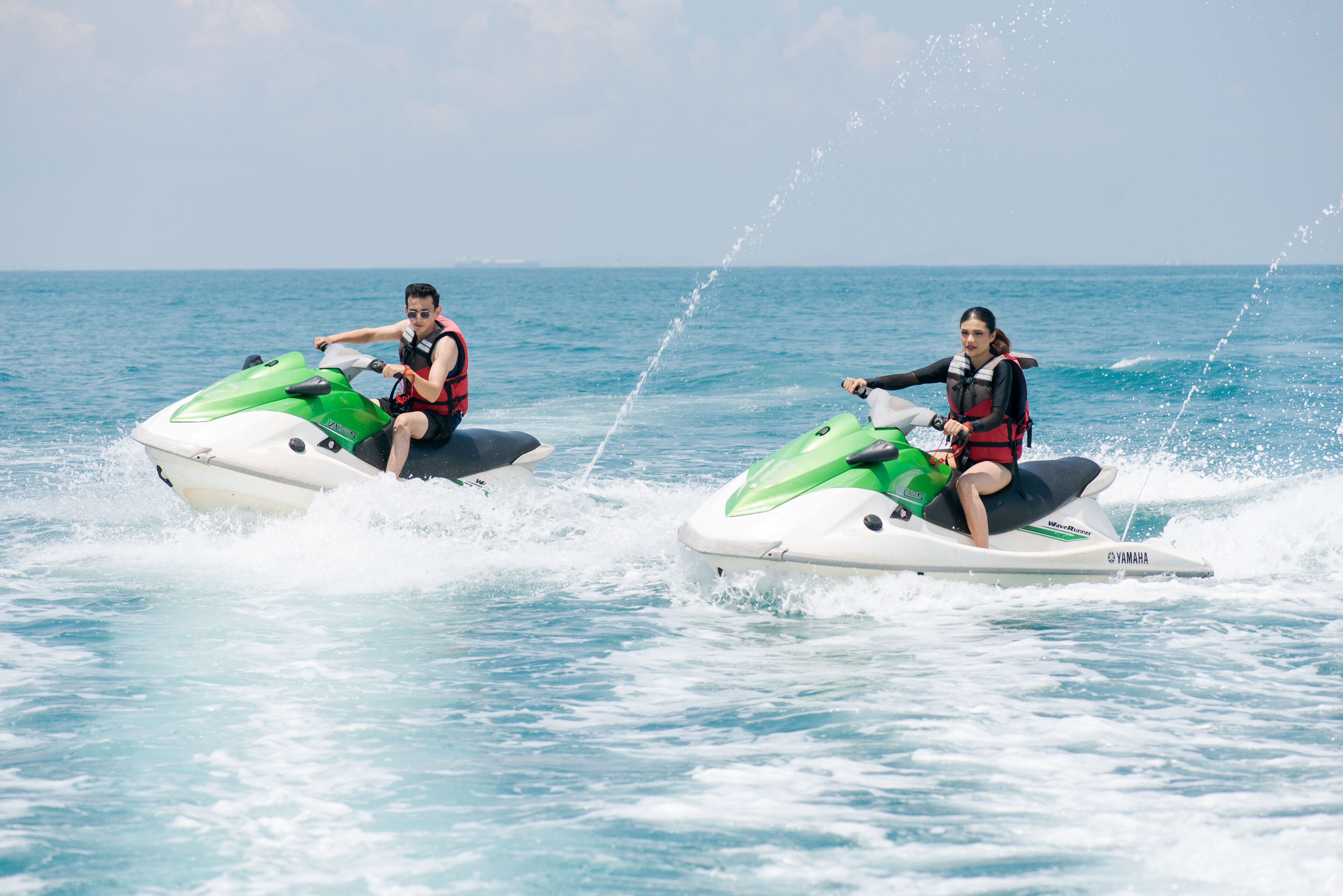 Two people jet-skiing on the water.