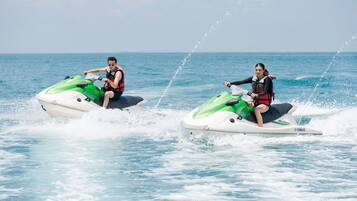 Two people jet-skiing on the water.