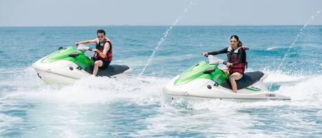 Deux personnes font du jet-ski sur l’eau.