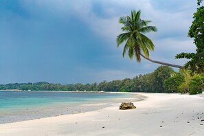 On the beach, white sand, sun loungers, beach towels