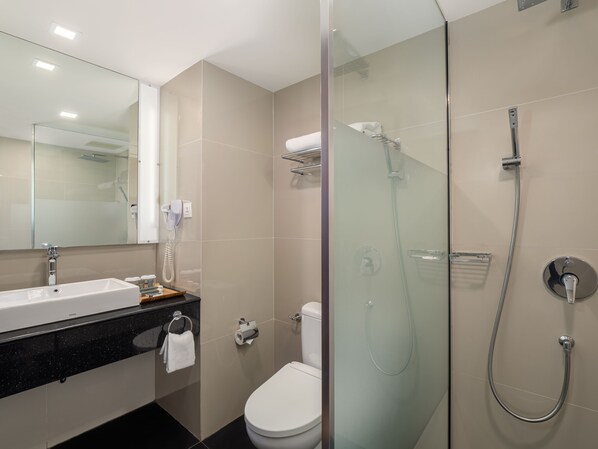 A modern bathroom with a glass-enclosed shower, a white sink, and a toilet. - Nirwana Resort Hotel (Bintan)