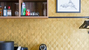 A kitchen with wooden cabinets, a coffee machine, and a cactus plant on the shelf. - The Highlander (Amsterdam)