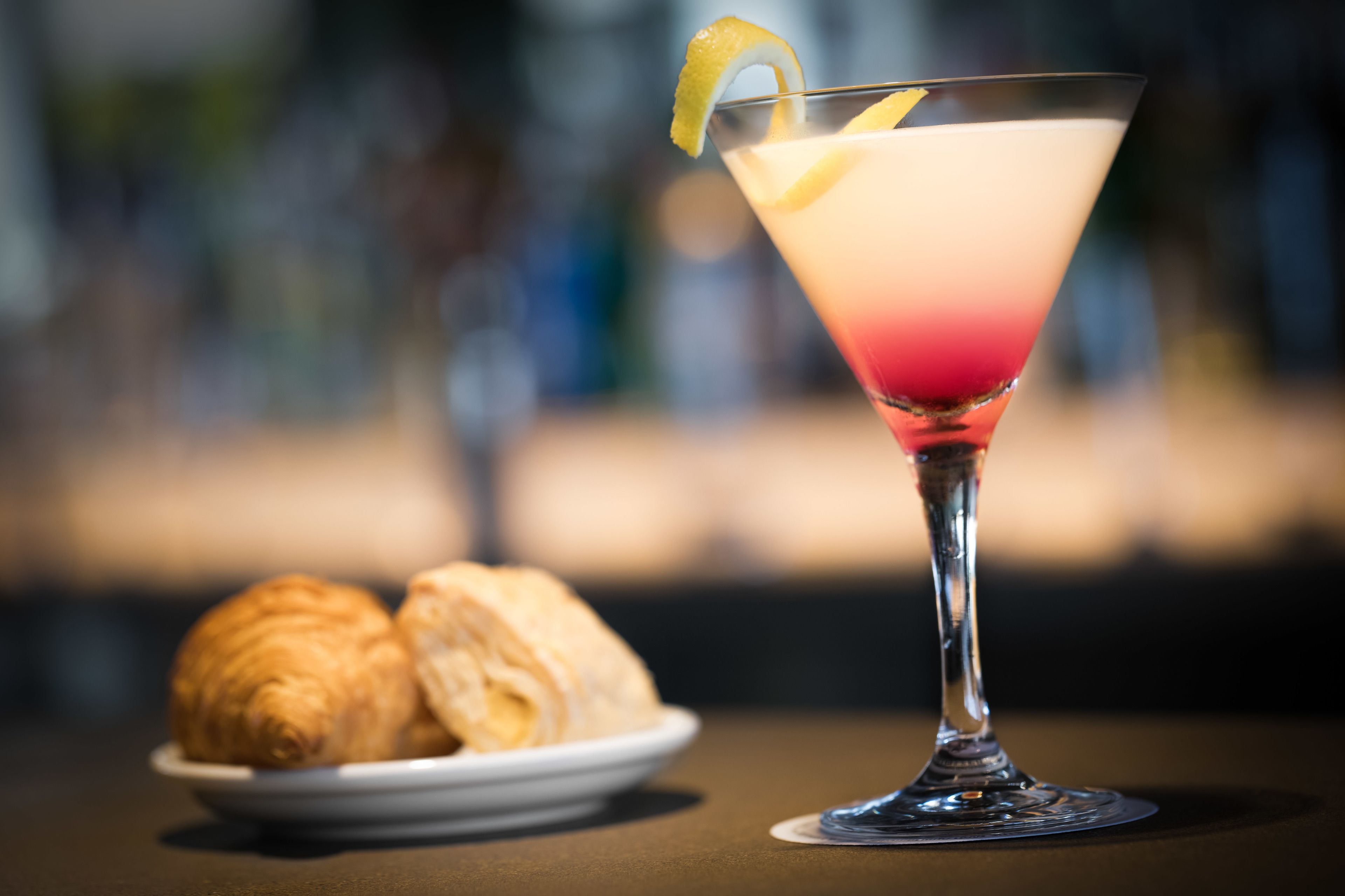Una copa de martini con una rodaja de limón sobre una mesa.