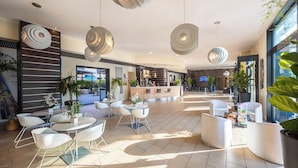 A modern hotel lobby with a reception desk, seating areas, and large pendant lights. - iH Hotels Milano Gioia (Milan)