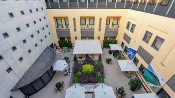 A courtyard with outdoor seating, a central garden, and multiple balconies.