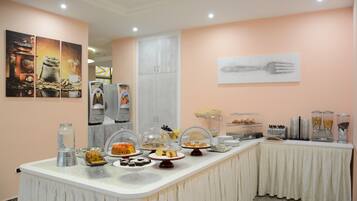 Montaje de bufé con diferentes alimentos y una estación de café.