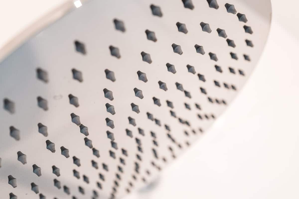 A close-up of a metallic colander with a perforated surface.