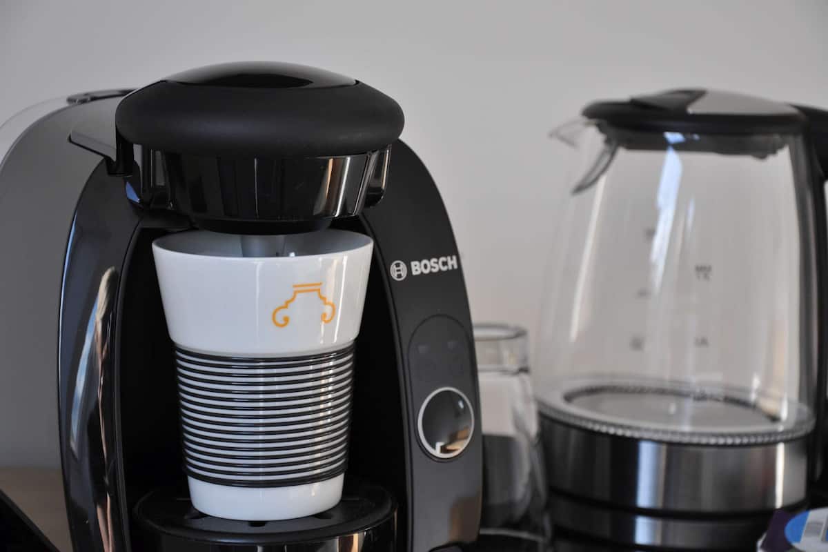 A coffee machine with a white cup holder and a Bosch logo.
