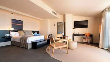 Una habitación de hotel moderna con una cama, un escritorio, una silla y un televisor.