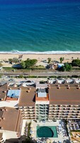 Vista aérea de un resort con piscina, playa y océano.