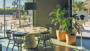 Un espace repas moderne avec une table ronde, des chaises et des plantes en pot.