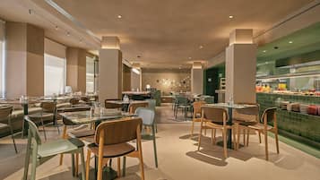 Een modern restaurant interieur met meerdere eetgedeeltes, waaronder een bar en een buffet.