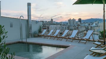 Una piscina al aire libre, tumbonas