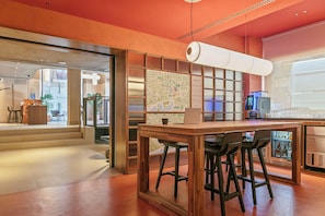 A modern bar area with a wooden counter, bar stools, and a map on the wall.