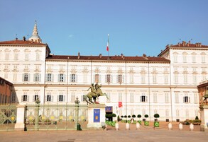 Un edificio storico con una statua di un uomo a cavallo di fronte.