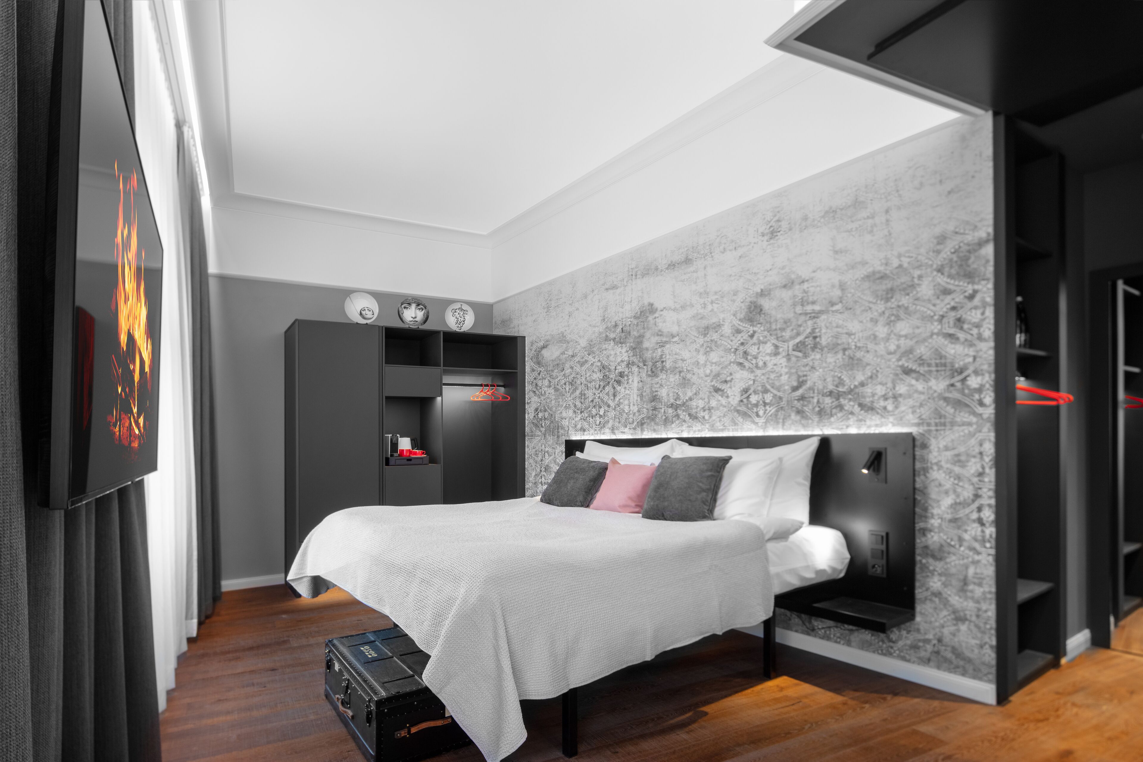 Ein modernes Schlafzimmer mit einem Bett, einem Kleiderschrank und einem Fernseher.