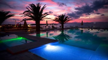 Una piscina al aire libre de temporada, sombrillas