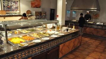 Ein Buffet mit verschiedenen Speisen und einer Küchenzeile im Hintergrund.