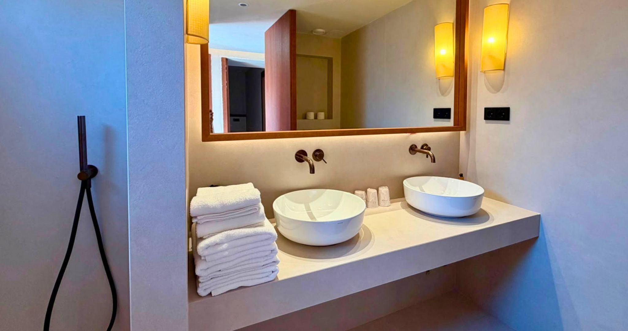 Un bagno con due lavandini, uno specchio e un portasciugamani.