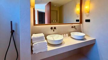 A bathroom with two sinks, a mirror, and a towel rack.