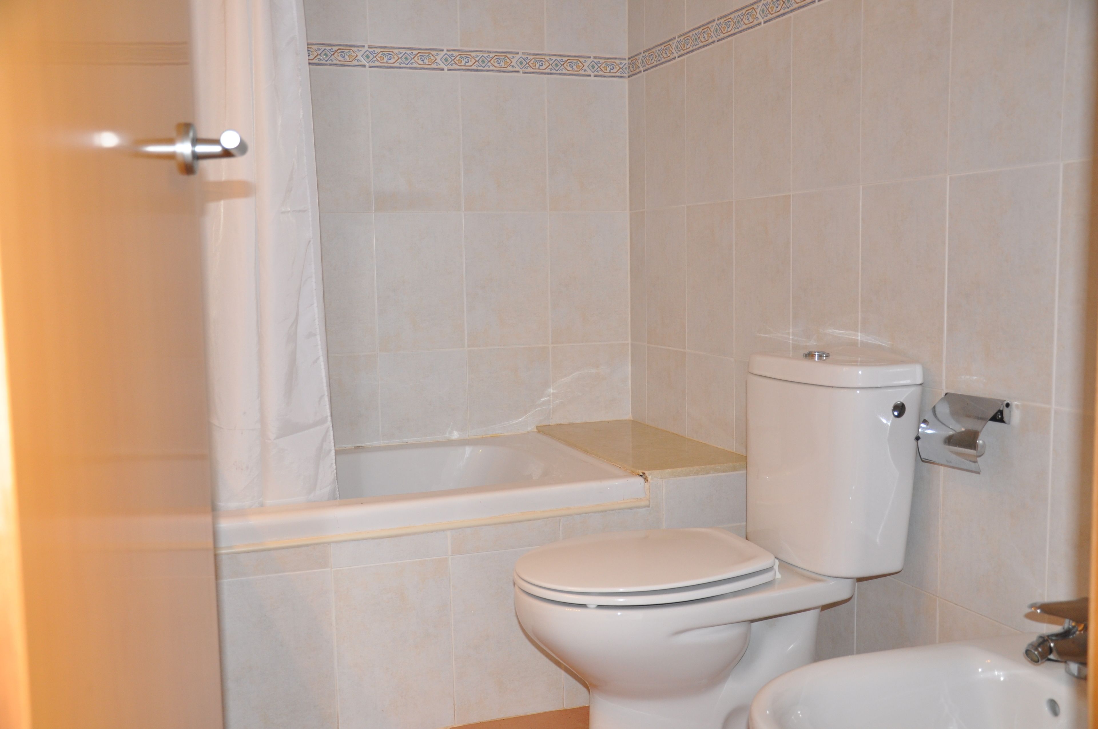A bathroom with a toilet, a bidet, and a bathtub.