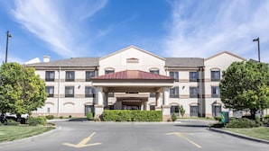 A multi-story hotel with a central entrance, large windows, and a landscaped driveway. - Quality Inn & Suites Guymon East (Guymon)