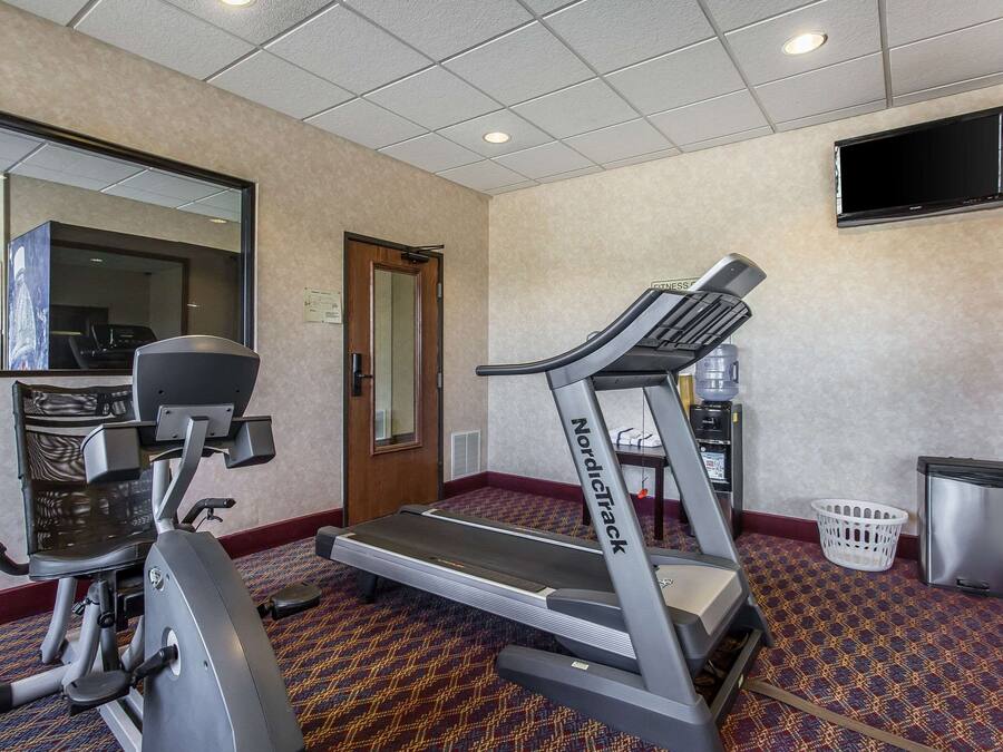 A gym with treadmills, a stationary bike, and a mirror on the wall.