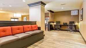 A hotel lobby with a seating area, a reception desk, and a computer station. - Comfort Suites Fairview Heights - St. Louis (Fairview Heights)