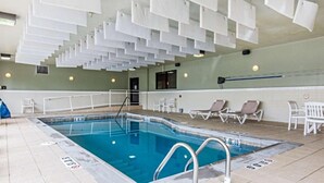 An indoor swimming pool with clear water, a diving board, and lounge chairs along the poolside. - Comfort Suites Fairview Heights - St. Louis (Fairview Heights)