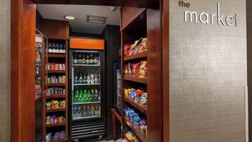 A grocery store interior with shelves stocked with snacks, beverages, and packaged goods.