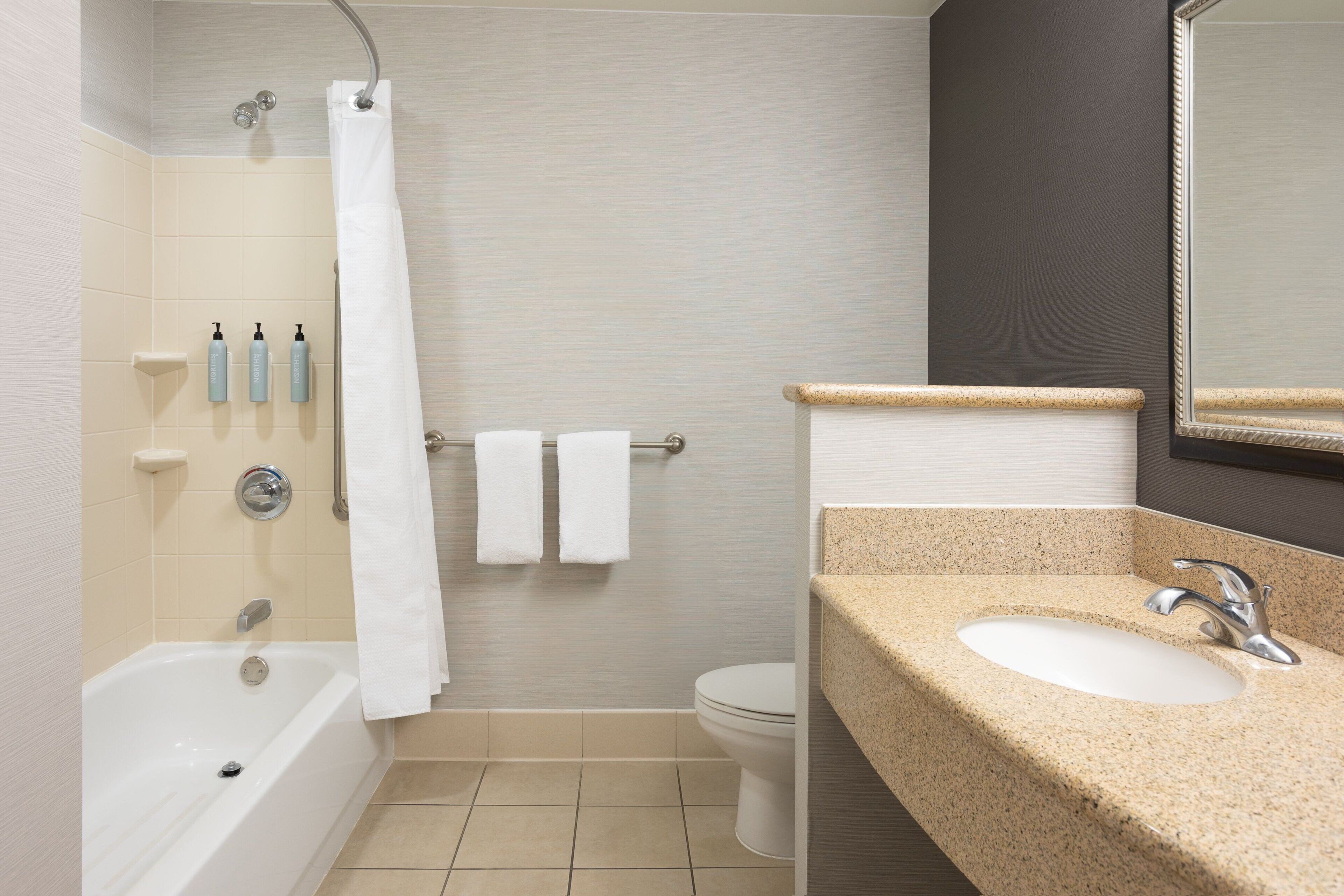 A bathroom with a bathtub, a toilet, a sink, and a shower curtain.