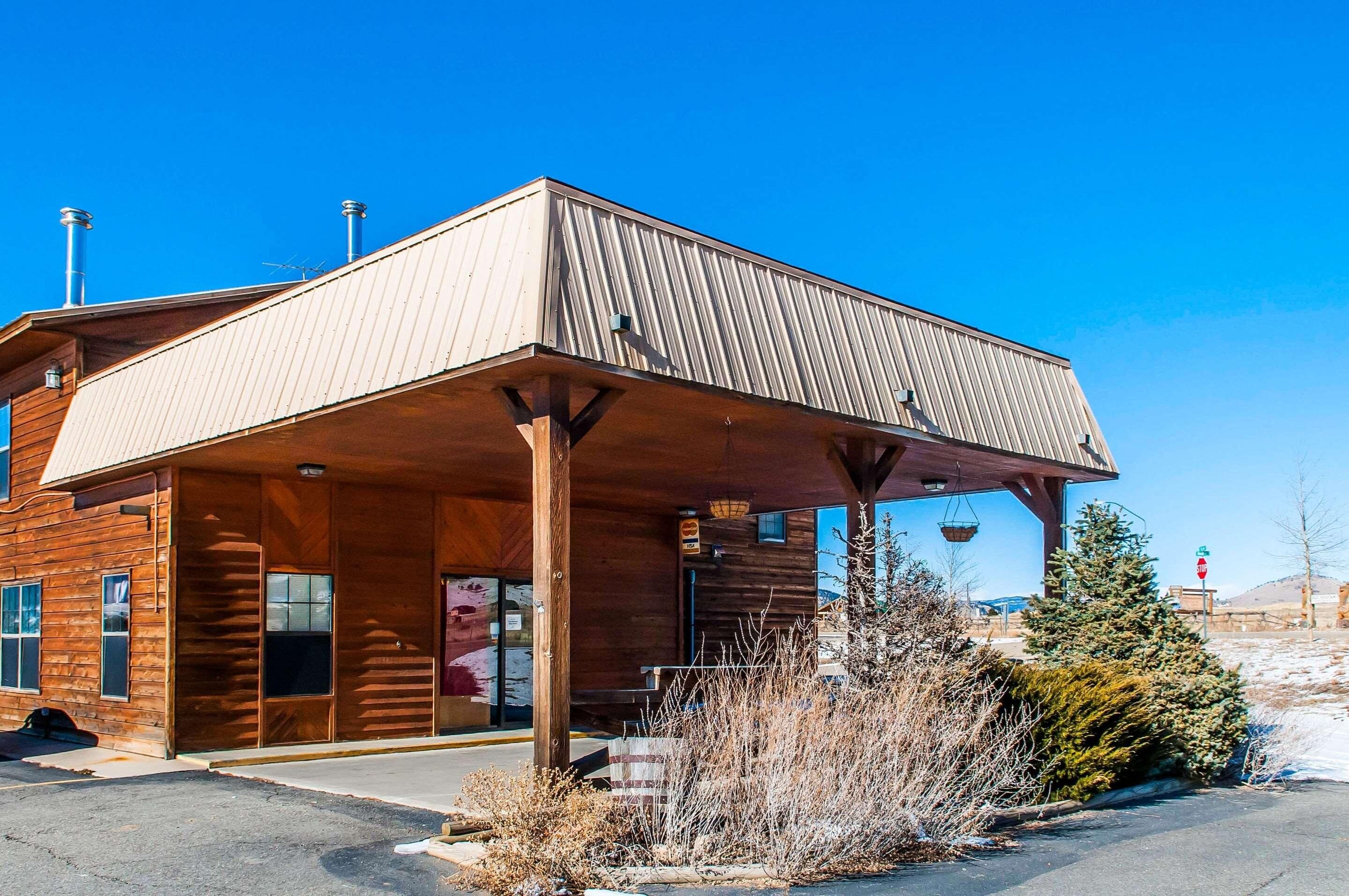 A wooden building with a covered entrance and a metal roof.